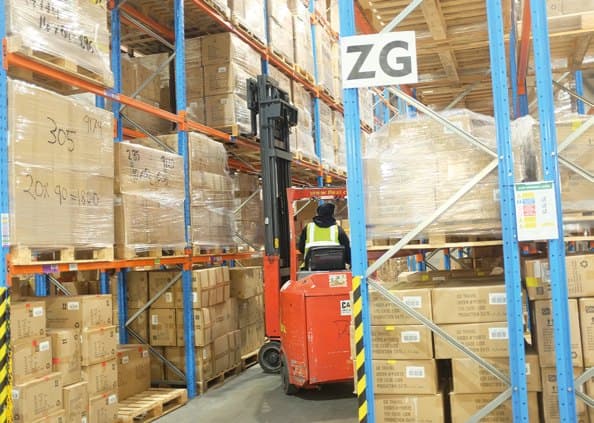 Warehouse operative moving stock by forklift