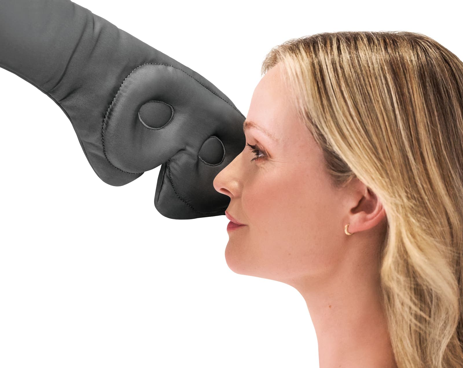 Grey silk eye mask held near a woman's face.