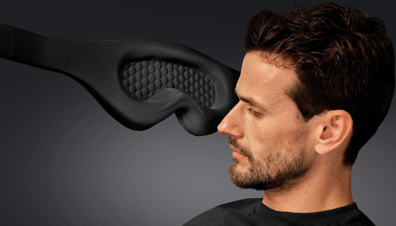 Man wearing a black GO TRAVEL eye mask.