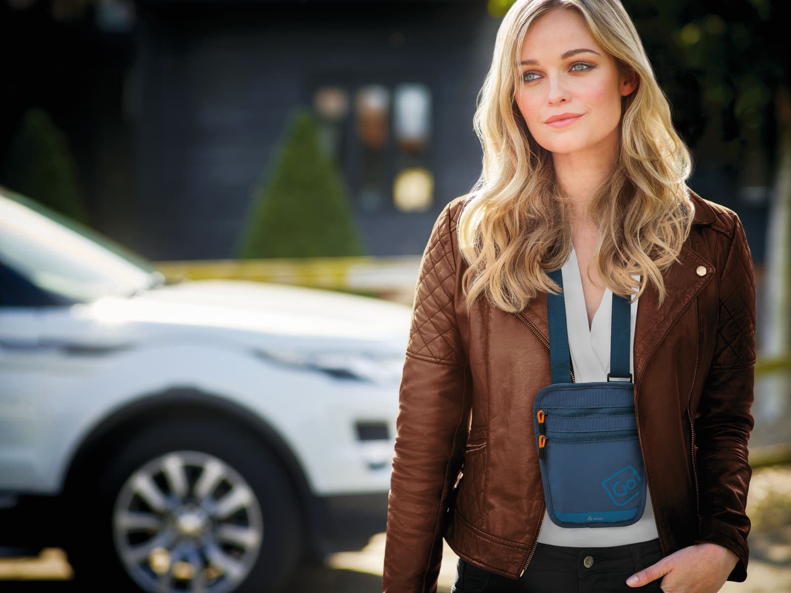 Woman wearing a blue GO TRAVEL RFID Passport Pouch outdoors.